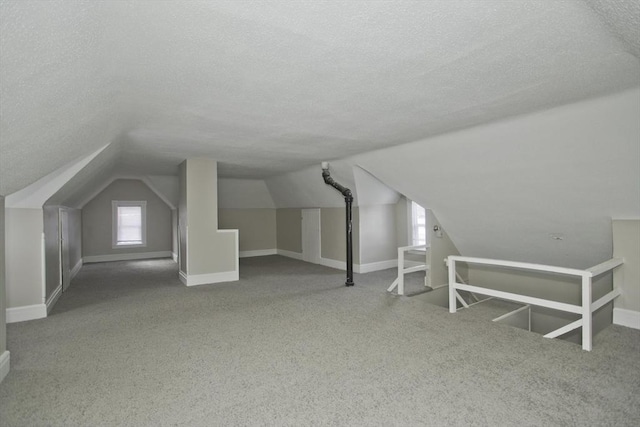 bonus room with carpet, a textured ceiling, and lofted ceiling