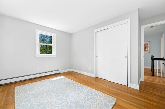 30 Eastview Rd, Hopkinton, MA 01748 - unfurnished bedroom featuring a baseboard radiator, wood finished floors, and a closet