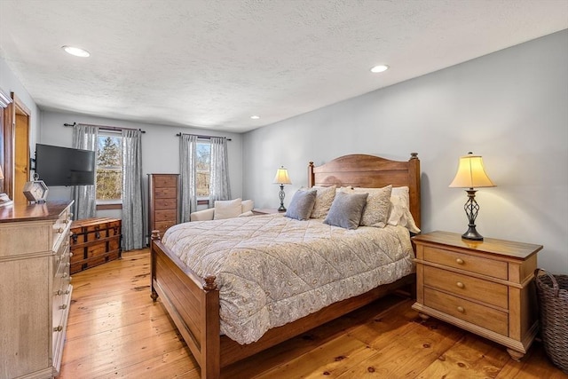 bedroom featuring recessed lighting, a textured ceiling, and light wood finished floors