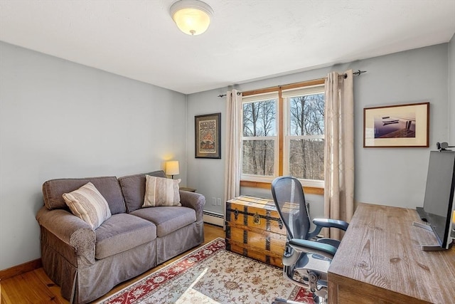 office area featuring baseboards, baseboard heating, and wood finished floors