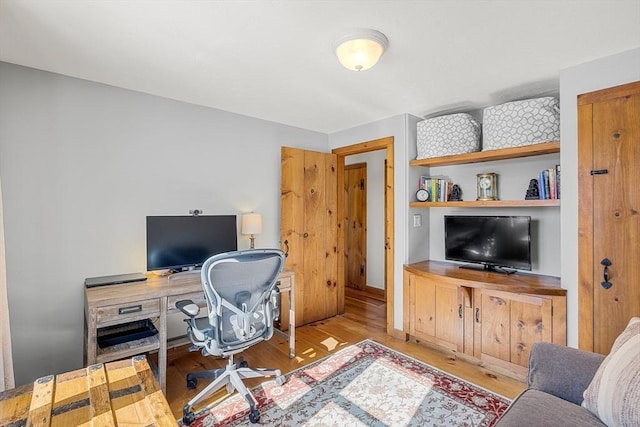 home office with wood finished floors and built in features