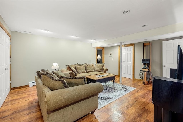 living area with light wood-type flooring, a baseboard radiator, baseboards, and recessed lighting