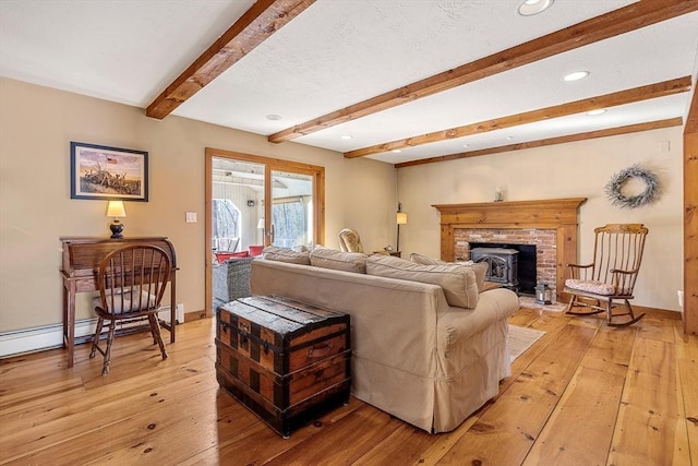 living room with a textured ceiling, beam ceiling, light wood-style flooring, and baseboards