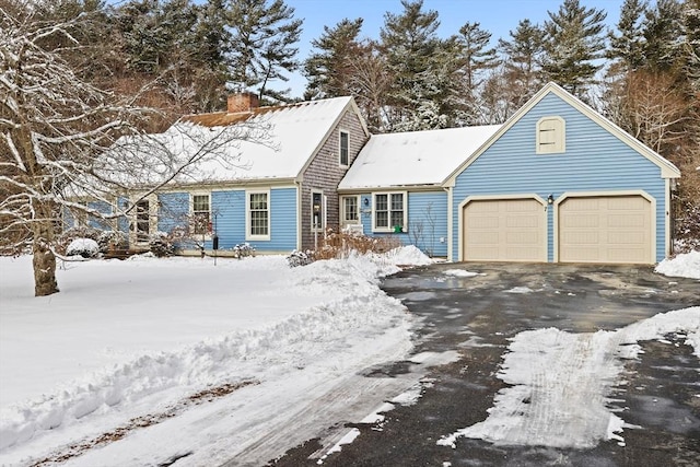 cape cod home featuring a chimney, driveway, and a garage