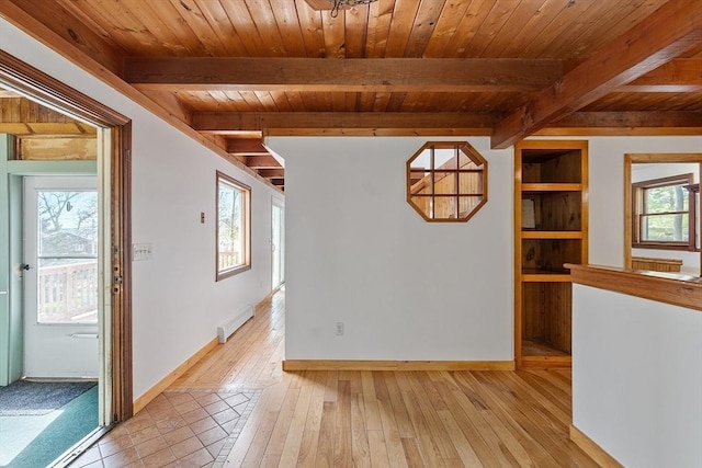 empty room with a healthy amount of sunlight, baseboards, and wood ceiling