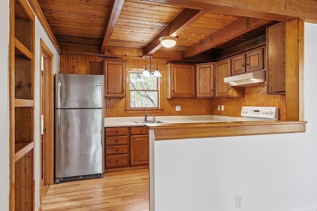 kitchen featuring brown cabinetry, light wood-style flooring, freestanding refrigerator, wooden ceiling, and under cabinet range hood