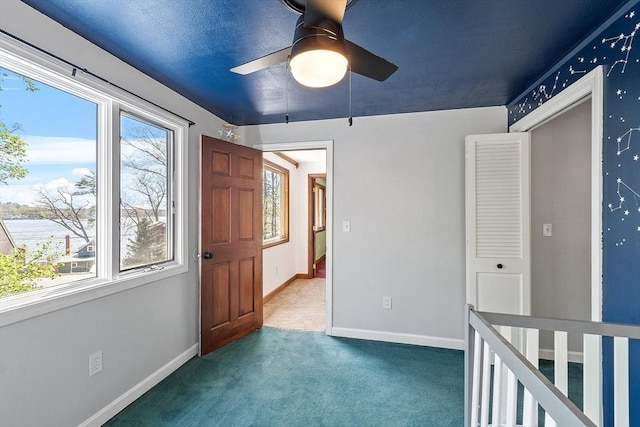 unfurnished bedroom with carpet floors, baseboards, and ceiling fan