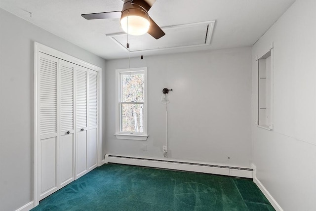 unfurnished bedroom featuring ceiling fan, attic access, baseboard heating, a closet, and dark carpet