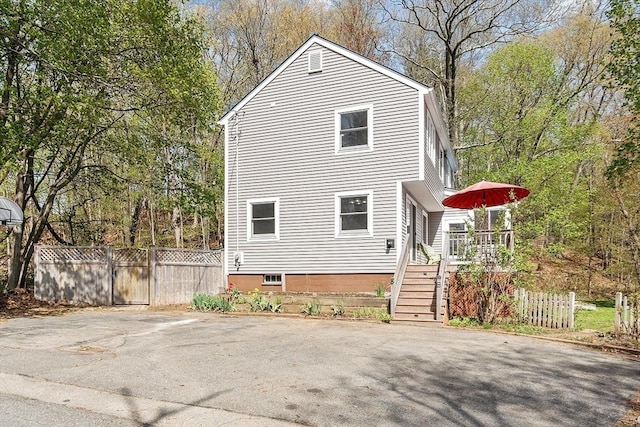 view of side of home featuring stairs, fence, and a deck