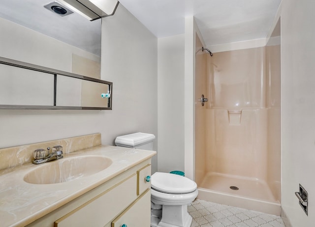 bathroom featuring vanity, toilet, a shower, and tile patterned flooring