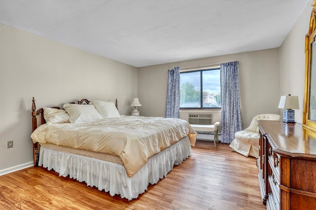 bedroom featuring light hardwood / wood-style floors and a wall mounted air conditioner