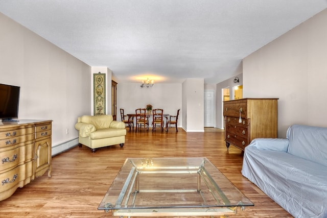 living room with light hardwood / wood-style floors, a textured ceiling, and a baseboard radiator