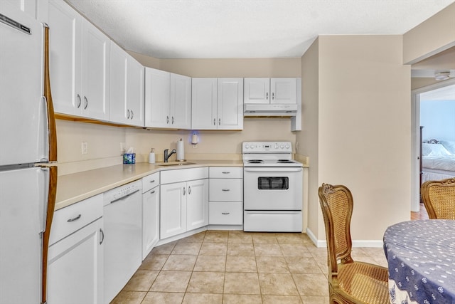 kitchen with white appliances, light tile patterned flooring, sink, a textured ceiling, and white cabinets