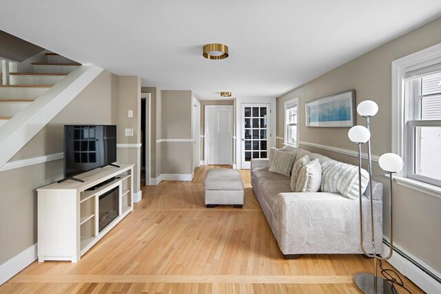 28 Ridge St, Arlington, MA 02474 - living area with light wood-style floors, baseboard heating, healthy amount of natural light, and stairway