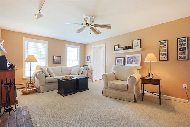 living room with carpet floors, a ceiling fan, and a healthy amount of sunlight