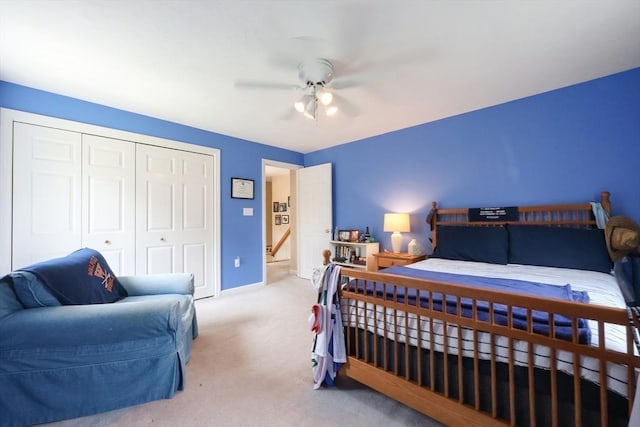 carpeted bedroom featuring a closet, baseboards, and ceiling fan