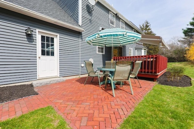 view of patio with a wooden deck and outdoor dining area
