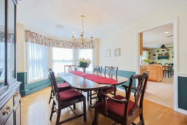 dining room with visible vents, crown molding, and a wealth of natural light