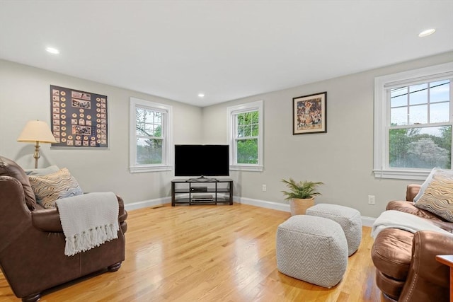 living room with light wood-type flooring, baseboards, and recessed lighting