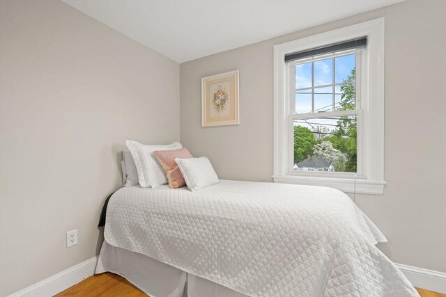 bedroom featuring baseboards and wood finished floors