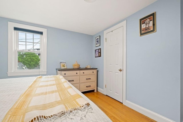 bedroom featuring light wood finished floors and baseboards