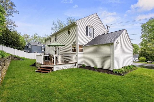 back of property with a wooden deck and a shingled roof