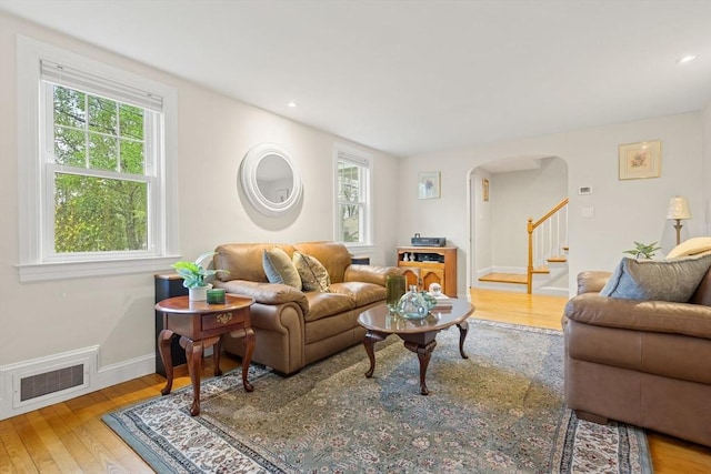 living area featuring healthy amount of natural light, arched walkways, hardwood / wood-style flooring, and recessed lighting