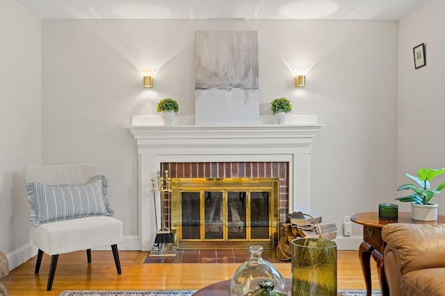 living area featuring a fireplace, wood finished floors, and baseboards