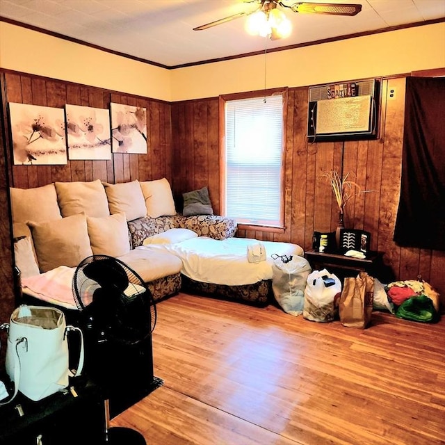 bedroom featuring crown molding, wood finished floors, wood walls, and ceiling fan