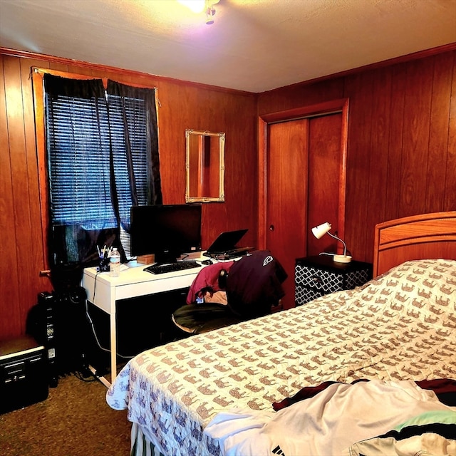 carpeted bedroom featuring a closet and wooden walls