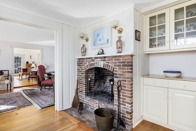 living room with a fireplace, hardwood / wood-style flooring, and crown molding