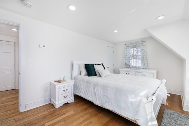 bedroom with lofted ceiling and light wood-type flooring