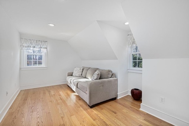 living area featuring vaulted ceiling and light hardwood / wood-style flooring