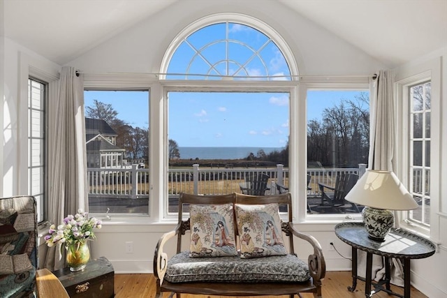 sunroom / solarium featuring a water view and lofted ceiling