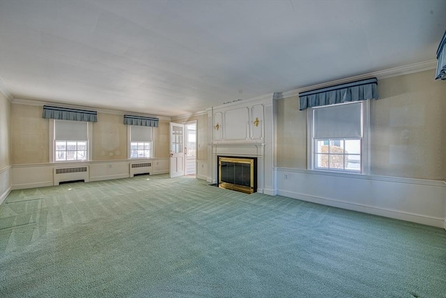 unfurnished living room featuring light carpet, a wealth of natural light, radiator heating unit, and crown molding