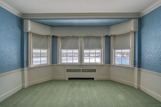 empty room featuring carpet floors, wallpapered walls, radiator heating unit, and crown molding