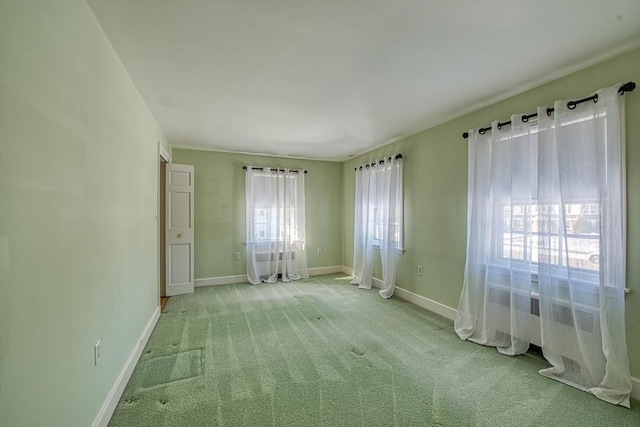 unfurnished room featuring light carpet and baseboards