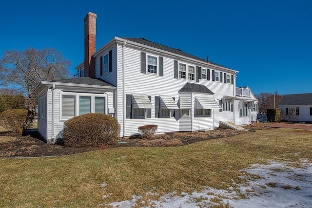 view of front of house with a chimney and a front lawn