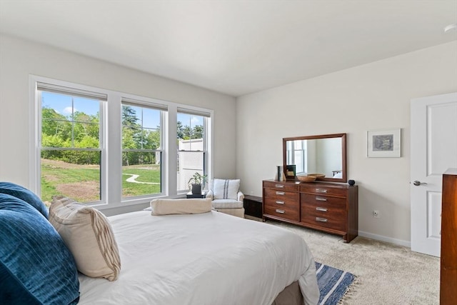 bedroom featuring light carpet and baseboards