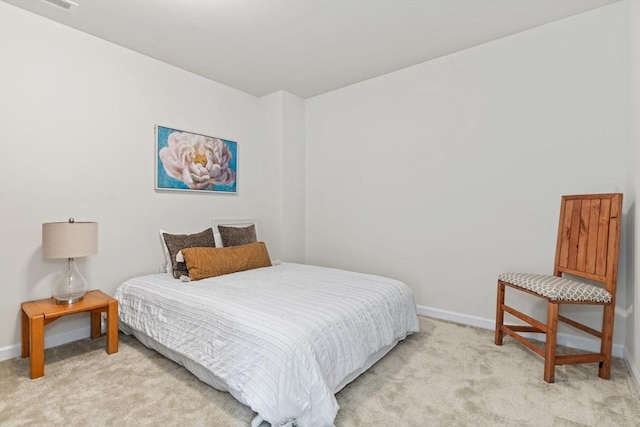 bedroom with light colored carpet and baseboards