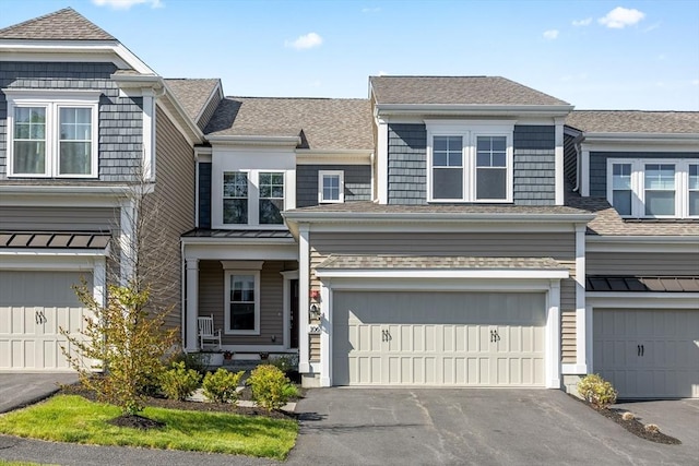 view of front of home with a garage, driveway, and roof with shingles