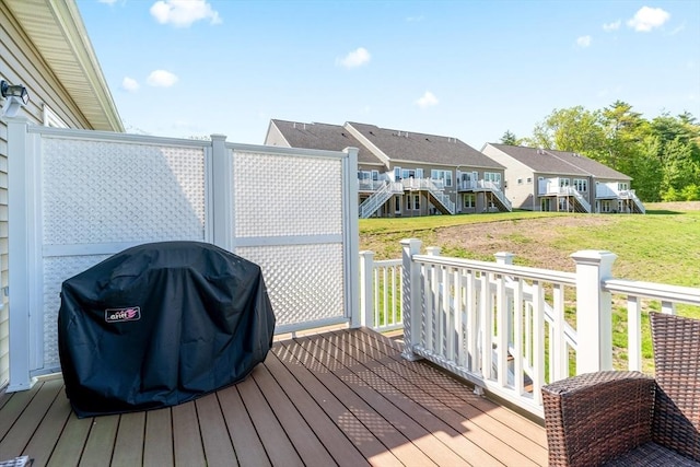 deck with grilling area, a residential view, a lawn, and stairs