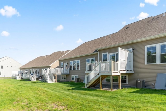 back of property featuring stairway, a wooden deck, central AC, and a yard