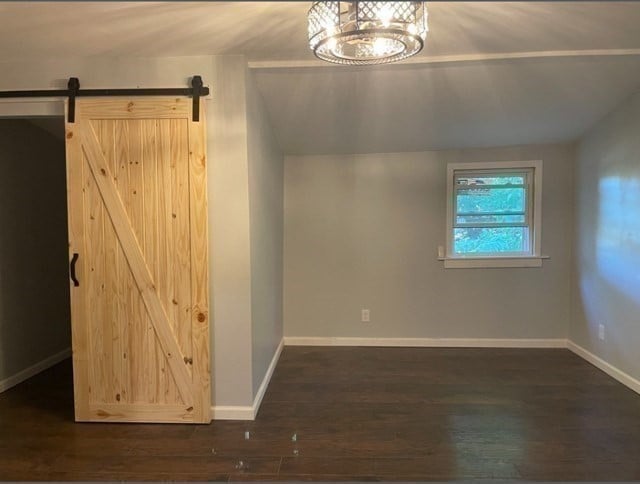 interior space featuring a barn door and dark hardwood / wood-style flooring