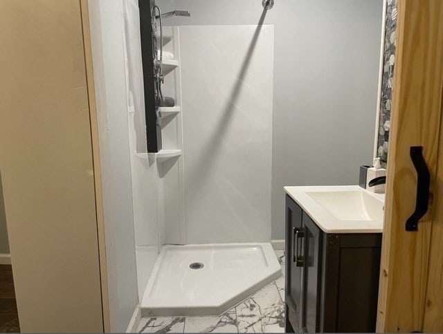 bathroom featuring tile flooring, vanity, and a shower