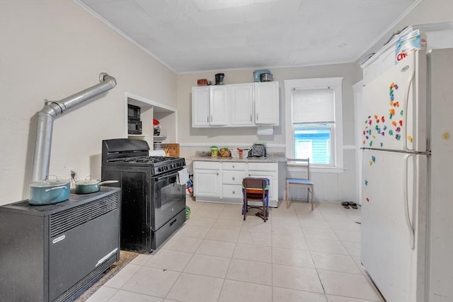 215 Beacon St, Worcester, MA 01610 - kitchen featuring freestanding refrigerator, black gas range oven, ornamental molding, white cabinets, and light tile patterned flooring