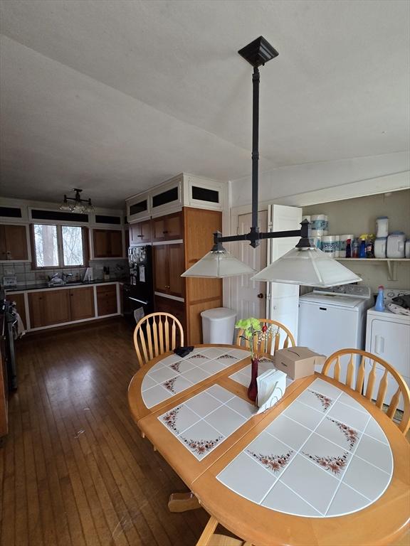 dining area with separate washer and dryer and dark wood-type flooring