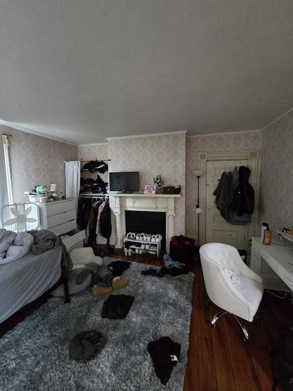 bedroom with wallpapered walls and wood finished floors