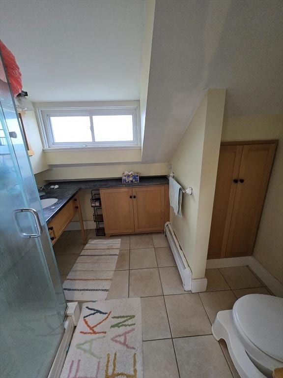 bathroom featuring a baseboard heating unit, tile patterned flooring, and a stall shower