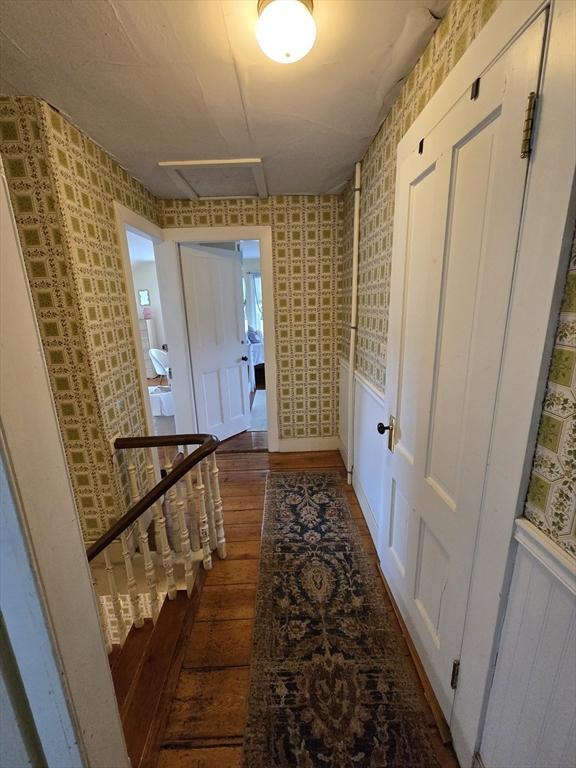 hall featuring hardwood / wood-style floors, attic access, and wallpapered walls